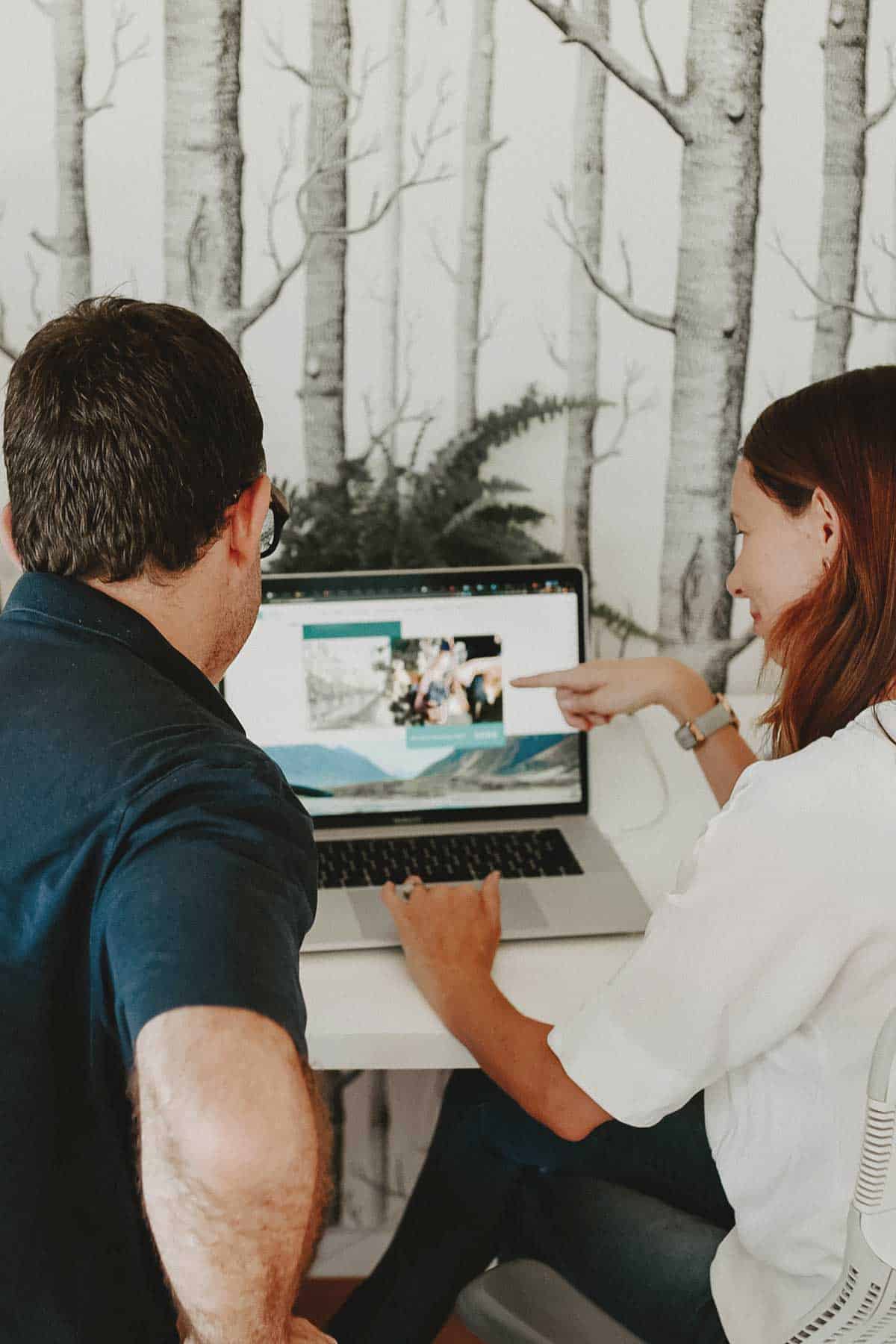 Liz and Gareth at a desk in the Weave studio, reviewing a website on a laptop